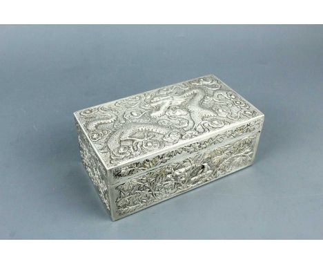 A Chinese silver ‘dragon’ box with hinged cover, early 20th century. Of rectangular form, the cover finely repoussé and chase