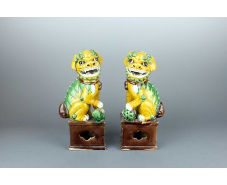 A pair of Chinese biscuit famille verte Buddhist lions, first half of the 20th century. Each modelled in mirror image, seated