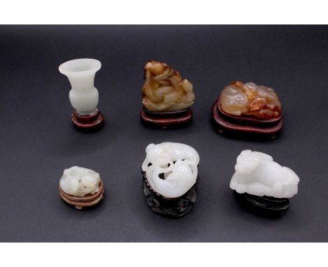 A group of six Chinese jade carvings, Qing Dynasty, comprising three white and pale celadon jade animal carvings, one agate a