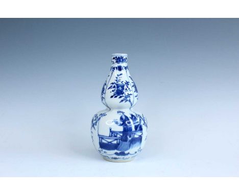 A Chinese blue and white double gourd vase, Qing Dynasty, late 19th century. The body is partitioned by vertical lines into f