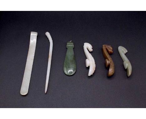 A group of six Chinese jade ornaments, Qing Dynasty, comprising two white and pale celadon jade hairpins, a spinach jade pend