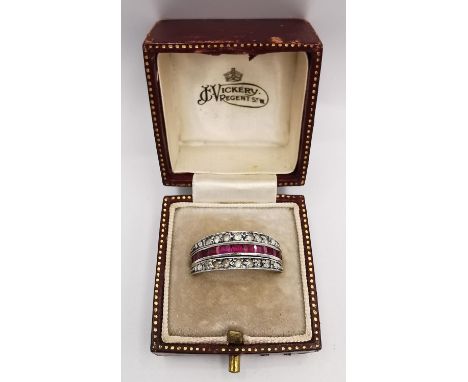 A boxed 9ct white gold Art Deco ruby and sapphire day night swivel eternity ring. Set with thirteen square cut sapphires in c