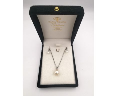 A boxed pair of 9ct white gold pearl and diamond earrings along with a pearl and diamond pendant and chain. The earrings in t
