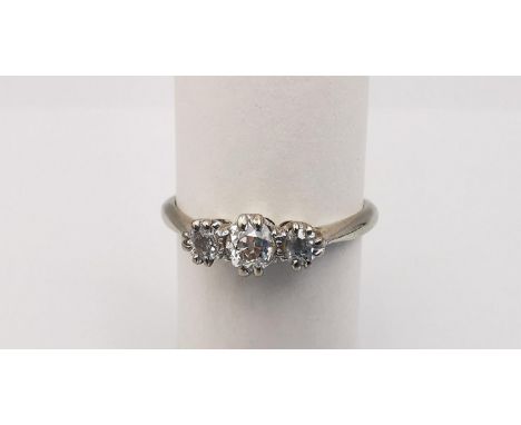 A boxed diamond platinum and 18ct white gold three stone ring. Set with three round old cut diamonds in open back double claw