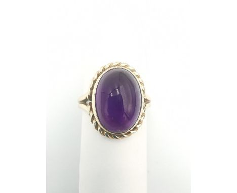 A 9ct yellow gold amethyst dress ring, set with an oval amethyst cabochon with an approximate carat weight of 5.83 carats, ro