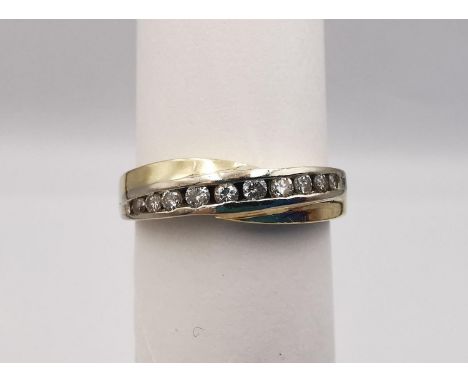 A 14 carat yellow and white gold diamond set twist half eternity ring. Set with ten round brilliant cut diamonds with a combi