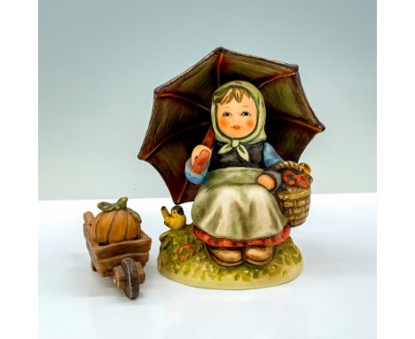 Smiling Through and Wheelbarrow. A figure of a village woman sitting on a hill holding an umbrella over her head next to a bi