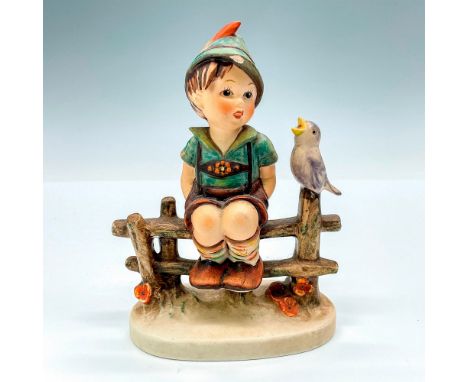As this young Bavarian boy rests on a wooden fence while being entertained by a chirping songbird. Dressed in traditional led