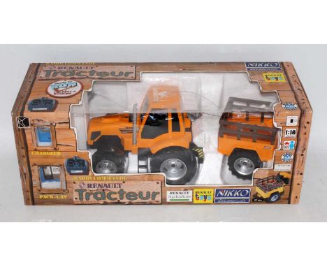 A Nikko radio controlled 27MHZ 1/18 scale Renault tractor and farm trailer, appears as issued, housed in the original window 