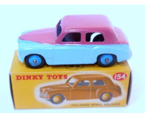 A Dinky Toys No. 154 Hillman Minx saloon comprising of two tone light blue and cerise upper body with mid blue hubs and house