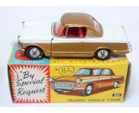 A Corgi Toys No. 231 Triumph Herald Coupe comprising of gold and white body with red interior and spun hubs housed in the ori