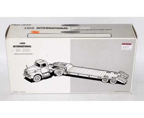 A First Gear 1/34 scale model of an International 1959 RF200 tractor unit with low loader trailer, housed in the original pol