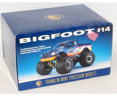 A Franklin Mint 1/24 scale diecast model of a Big Foot Monster Truck finished in metallic blue with fire livery, racing No. 1