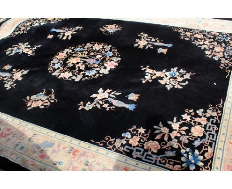 A Chinese black ground carpet with floral decoration, 260cm x 360cm.