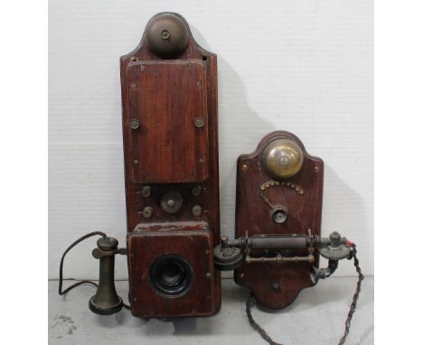 A wall-mounted early 20th century telephone, metal receiver with Bakelite handle mounted beneath a swing arrow switch numbere