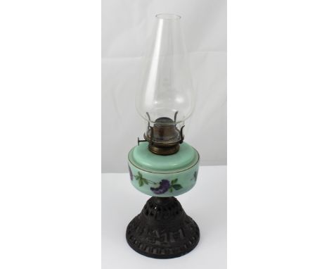 An early 20th century green glass floral-decorated oil lamp on a filigree metal base, height 47cm.