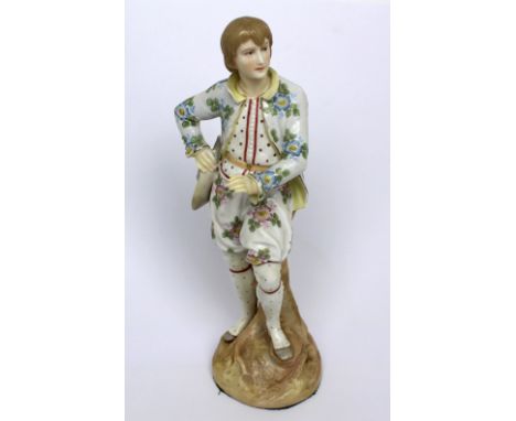 A Continental figure of a young man in period costume, floral-decorated jacket and breeches and large sunhat in hand, on a st
