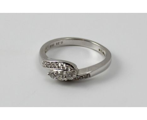 An 18ct white gold and diamond ring, the three central round brilliant cut stones flanked by smaller stones to both shoulders