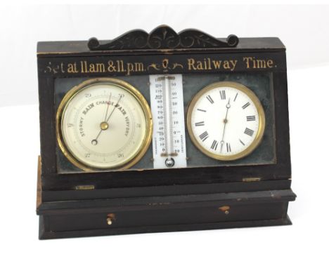 An ebonised cased clock, thermometer and barometer inscribed 'Set at 11am & 11pm Railway Time', width 40cm.