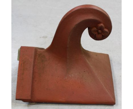 An early 20th century end ridge roof tile with floral finial, approx 33 x 36.5cm.