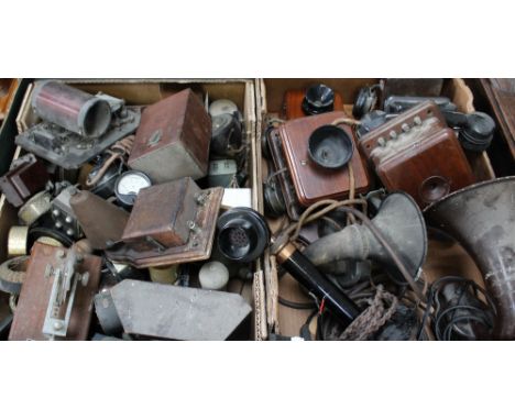 A box of assorted vintage telephones to include a black stick example, a wall-mounted Bakelite and metal example, three wall-