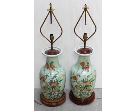 A pair of modern Limoges porcelain baluster lamp bases with Chinoiserie pomegranate decoration to a celadon green ground, eac
