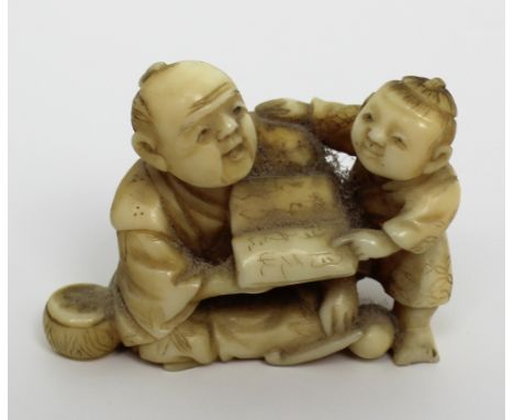 A Japanese Meiji period netsuke of a scholar and child, height 3cm (af).