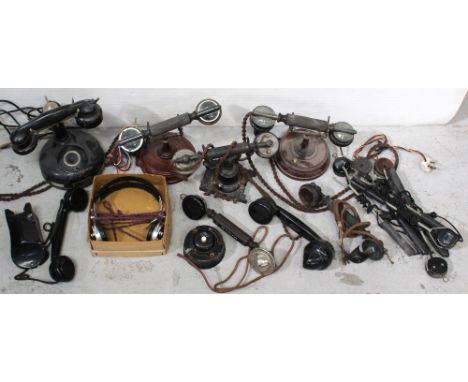 A box of early 20th century vintage telephone receivers, mid-20th century telephone microphone wands, also two mahogany-based