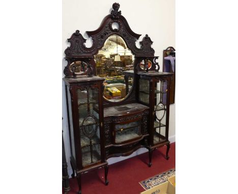 An impressive floral relief carved mahogany mirrorback display cabinet, in the Chippendale taste, the shaped bevelled mirrorp