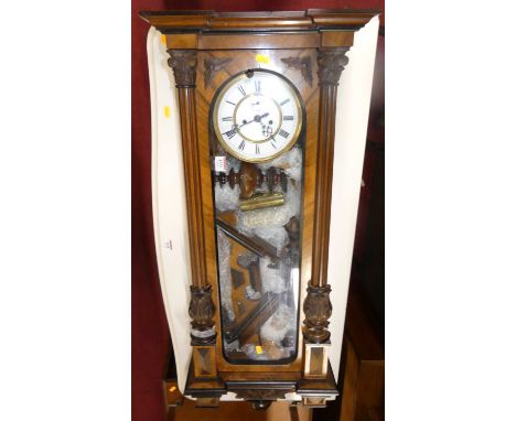 A circa 1900 walnut Vienna drop trunk wall clock, with striking and chiming movement, two weights and pendulum