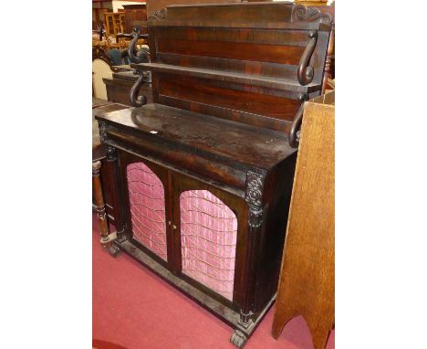 A William IV rosewood chiffonier, having twin shelved raised superstructure, cushion frieze drawer over two arched brass trel