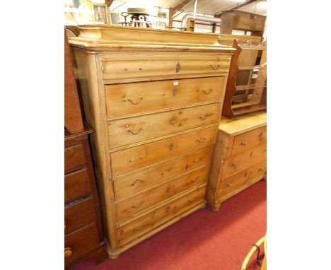 A French provincial stained pine round cornered chest of seven long drawers, comprised of two sections and raised on squat bu