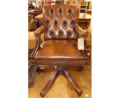 A contemporary mahogany tan leather button back and further studded swivel desk elbow chair, width 55cmLeather is in good con