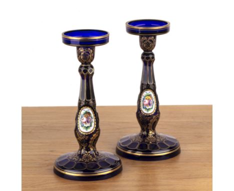 Pair of Bohemian glass candlestickswith enamel and gilt painted decoration of flowers, on a cobalt blue ground, unsigned, 29c
