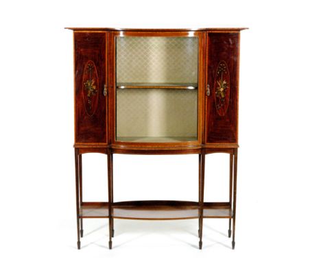 An early 20th Century mahogany bow fronted display cabinet, the central glazed panel door flanked by a floral painted door pa