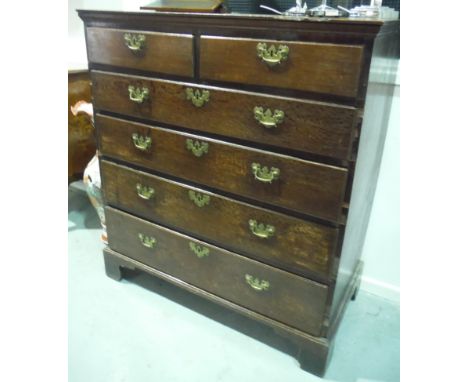 A George III oak straight front chest of four long drawers fitted with brass fret drop handles, on bracket feet, width 110cm.
