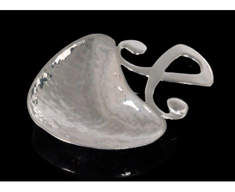 An Arts and Crafts hallmarked silver caddy spoon with heart shaped planished bowl below scrolled handled, Birmingham 1926, Wi