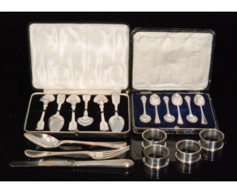 A cased set of four hallmarked silver napkin rings of plain circular form Birmingham 1925 and a cased knife fork and spoon se