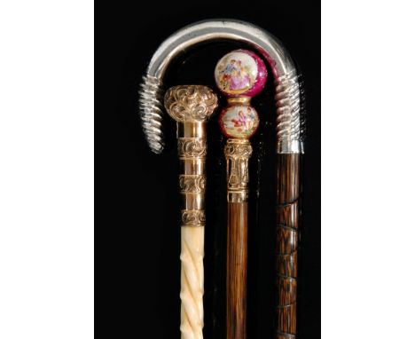 A Victorian engraved gold plated walking stick together with a silver handled walking cane and a double ceramic French ball w