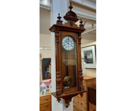 A Vienna style walnut wall clock eight inch white enamel dial in case with finials, mask mount and turned column uprights, 14