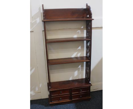 A Chippendale style floor standing four-tier shelf pierced sides and base with four small drawers, 50cm