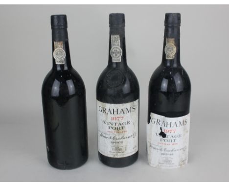 Three bottles of Graham 1977 vintage port one missing paper label (some evidence of leakage)