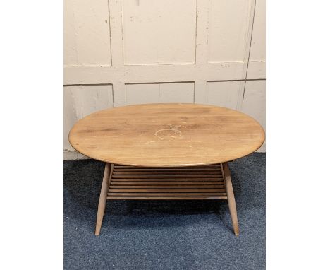 An Ercol light elm oval coffee table with undertier (a/f) 99cm