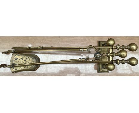 A set of three brass fire irons and an andiron