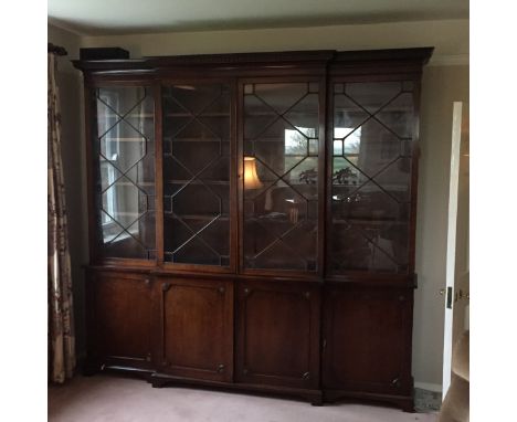A late C19th plum pudding mahogany astragal glazed brakefront bookcase. The glazed panel doors above panel doors with Rose ro