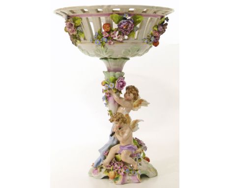 A Dresden ceramic centre-piece with basket, cherubs and foliate design Condition reports are not available for our Interiors 