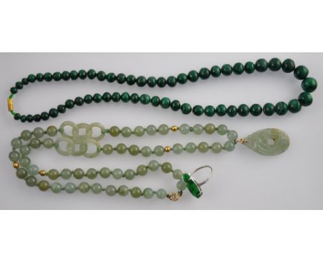 A necklace of graduated malachite beads, a similar jade necklace with pierced oval carved dragon pendant, and an 18ct white g