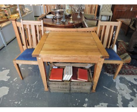 A 1930's light oak folding dining table with four similar dining chairs