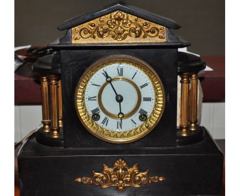 A late Victorian gilt metal mounted black slate eight day mantle clock with circular white enamel dial marked Roman numerals