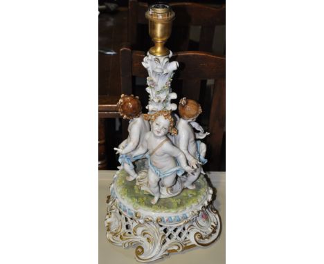 A pair of 20th Century French porcelian cherub lamp bases on pierced scroll bases with shades, H. 54cms, together with a simi